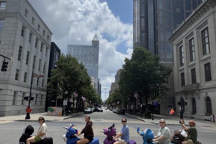 People riding miniature vehicles in costumes on a city street.