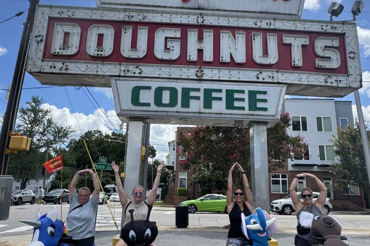 Group in wheelchairs under Krispy Kreme Doughnuts sign.